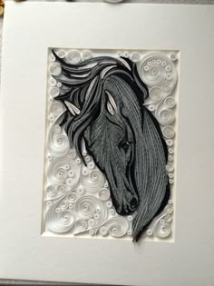 a card with a black horse head on it's front and back sides, surrounded by white swirls