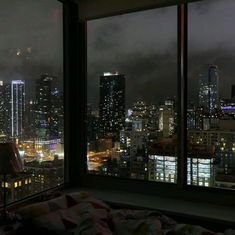 a view of the city lights from a bedroom window