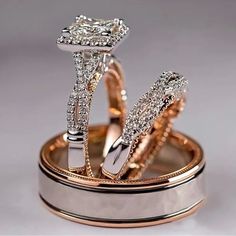 two wedding rings with diamond accents on top of each other in gold and silver cases