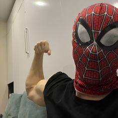 a man wearing a spider - man mask and flexing his muscles