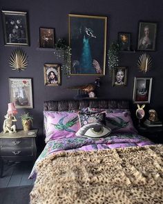 a bed room with a neatly made bed and many pictures on the wall above it