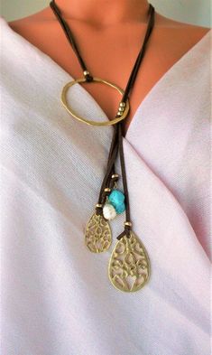 Lovely Leather Lariat necklace. Genuine Turquoises tassel, Unique design NEW vacation Jewelry purchase, never used This is a stunning statement necklace Components include: shiny gold tone quality Brass Genuine 31 inch flat Leather 6 inch Leather Tassel with stone and Brass dangles Handmade in Asia Ready to ship NO waiting Only ONE necklace available Thank you so much for visiting :kaysclassyboutique@etsy.com Bohemian Metal Lariat Necklace With Adjustable Length, Bohemian Metal Lariat Necklace As A Gift, Bohemian Metal Lariat Necklace As Gift, Adjustable Metal Tassel Necklace As Gift, Adjustable Turquoise Elegant Lariat Necklace, Bohemian Metal Lariat Necklace With Dangle, Bohemian Metal Lariat Necklace, Bohemian Lariat Necklace With Tassels For Gifts, Adjustable Long Tassel Necklace