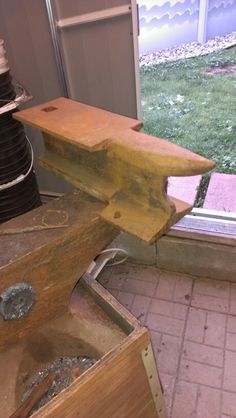 a piece of wood sitting on top of a wooden box next to a window sill