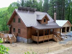 a house with a metal roof in the woods