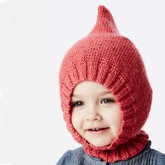 a young child wearing a knitted hat and scarf