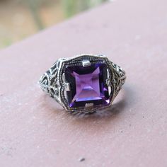 Vintage Sterling Silver Princess cut Amethyst Filigree Ring ...Marked 925...Total of weights 3.4grams...Size 8...Measure of Face 12.9MM...It's in very good condition. Purple Sterling Silver Filigree Jewelry, Purple Hallmarked Art Deco Amethyst Ring, Art Deco Purple Amethyst Ring, Purple Jewelry For Formal Occasions, Classic Hallmarked Purple Jewelry, Antique Purple Amethyst Ring With Accent Stones, Formal Purple Amethyst Ring With Filigree, Art Deco Purple Amethyst Ring For Anniversary, Purple Amethyst Ring With Filigree