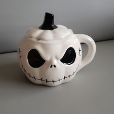 a ceramic teapot with a skeleton face on it