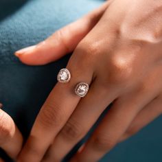 a woman's hand with two diamond rings on it