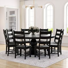 a dining room table and chairs in front of two large windows with white trimmings