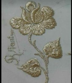 some gold flowers on a white cloth with the word love spelled in silver glitters