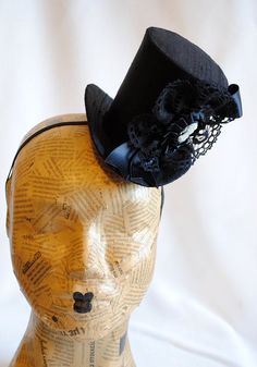 This victorian goth mini top hat is a simple yet elegant piece.It is covered with black silk shantung and adorned with black satin ribbon in a vertical half bow, vintage black cotton lace in a rosette, pleated satin ribbon, which forms an oval frame for a beautiful black and white victorian profile cameo. Choose between with or without black veil. Also available in a white and black combination: https://www.etsy.com/bizarrenoir/listing/166826619/gothic-mini-top-hat-in-purple-velvet?ref=shop_home Black High Crown Costume Hats And Headpieces For Wedding, Black High Crown Costume Hat For Wedding, Handmade Fitted High Crown Mini Hats, Handmade Fitted Mini Hat With High Crown, Fitted High Crown Costume Hats For Themed Events, Fitted High Crown Hats For Themed Events, Handmade Black Gothic Costume Hats And Headpieces, Fitted High Crown Costume Hat For Carnival, Fitted High Crown Hat For Carnival