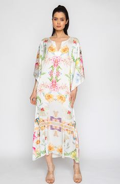 Bring out your inner flower in the Botanica Long Caftan. This gorgeous piece of apparel features delicate flowering patterns, giving you the freedom to show off your unique style. And the airy fabric won’t weigh you down, meaning you can wear your beauty around the clock! Bloom into something special with the Botanica Long Caftan. Printed short caftan Can be worn loose or cinched at the waist Comes with a matching belt as an option for styling Lusciously soft poly-silk blend for ease of care Mac Floral Print Flowy Maxi Cover-up, V-neck Floral Print Tunic For Beach Cover-up, Elegant Spring Kaftan For Beach Cover-up, Spring Floral Print V-neck Kaftan, Bohemian V-neck Tunic With Floral Print, Flowy Tropical Cover-up With Floral Print, Bohemian Long Kaftan For Spring, Spring Beachwear Maxi Tunic, Spring Bohemian Kaftan With Kimono Sleeves