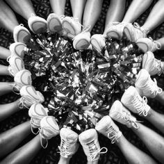 a group of people standing around each other with their feet in the middle of them