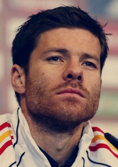 a close up of a person wearing a jacket and tie with a serious look on his face