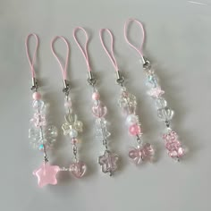 five different colored beads with bows and hearts on them are hanging from lanyards