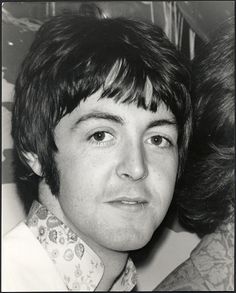 an old black and white photo of a young man with his hair in a bun