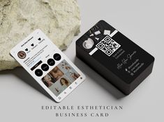 a black and white business card next to a rock with qr code on it