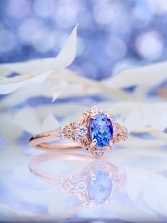 a close up of a ring with a blue and white stone in it on a table