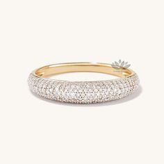 a gold and white diamond ring with a flower on the top, set in 18k yellow gold