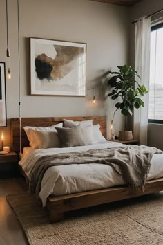 a bedroom with a large bed and two candles on the nightstands next to it