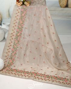 Embrace the ethereal charm of our Oatmeal-White floral embroidered organza saree, paired with an exquisitely crafted printed blouse. The sheer, airy fabric adorned with delicate floral embroidery captures a timeless elegance and modern sophistication. Perfect for any special occasion, this ensemble ensures you radiate grace and beauty. Step into a world of refined allure and leave a lasting impression. The blouse comes with an added allowance, and it can be altered to a standard size of 34"-42" Organza Traditional Wear With Floral Embroidery For Receptions, Floral Embroidery Organza Traditional Wear For Reception, Floral Embroidered Organza Traditional Wear For Reception, Organza Saree With Floral Embroidery For Reception, Reception Organza Saree With Floral Embroidery, White Tissue Silk Traditional Wear With Floral Embroidery, Reception Tussar Silk Dupatta With Resham Embroidery, Organza Embroidered Fabric For Eid Reception, Off White Tissue Silk Traditional Wear With Dupatta