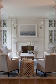 a living room filled with furniture and a fire place in front of a painting on the wall