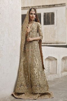 a woman in a bridal outfit leaning against a wall