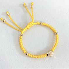 New. Stainless Steel Puffed Heart Ajustable Knotted Bracelet. Color Yellow. Handmade With 6mm Golden Stainless Steel Beads Enclosed With Knots On A Braided Cord Creating A Stylish Design. A Focal Stainless Steel Puffed Heart Is The Star Of This Bracelet. Adjustable With Macrame Sliding Closure. Wear It Alone Or Create Stacks Combinations With More Bracelets. Perfect Gift For Valentines Day, Mother’s Day, Christmas, Birthdays, Anniversaries Or Simply For Yourself. Adjustable Yellow Jewelry With Heart Beads, Adjustable Yellow Gold Bracelet With Heart Beads, Casual Yellow Beaded Bracelets With Sliding Knot, Casual Yellow Beaded Bracelet With Sliding Knot, Adjustable Yellow Macrame Jewelry, Casual Yellow Jewelry With Sliding Knot, Yellow Beaded Bracelets With Sliding Knot As Gift, Yellow Beaded Bracelets With Sliding Knot For Gifts, Yellow Beaded Bracelet With Sliding Knot As Gift