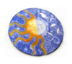 a blue plate with an orange and yellow sun design on the front, sitting on a white surface