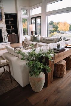 a living room filled with furniture and a fire place in front of a large window