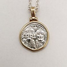 Byzantine-era coins were believed to be talismans against evil spirits, their mystical energy would give prosperity and luck to the one wearing them. It was a common practice to give such coins as gifts to newborns to protect them. This is a special statement piece, a hand-forged solid 14k yellow gold frame holds a solid sterling silver coin, exact copy of the ancient one, and hangs from a silver chain creates an ideal layering necklace. Elegant, classy, boho, classic and modern at the same time Antique Gold Sterling Silver Coin Necklace, Antique Sterling Silver Gold Coin Necklace, Byzantine Coin Jewelry For Ceremonial Occasions, Byzantine Style Coin Jewelry For Ceremonial Use, Byzantine Coin Pendant Jewelry, Byzantine Round Coin Pendant Jewelry, Byzantine Style Coin Pendant Jewelry, Handmade Sterling Silver Byzantine Jewelry, Byzantine Style Round Coin Pendant Jewelry