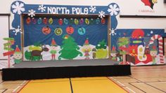 a stage set up for a christmas party with decorations on the wall and around it