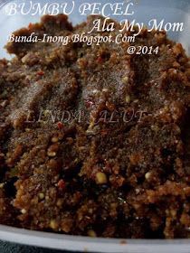 a close up of food in a bowl on a table with the words bumba pecel