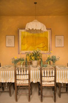 a dining room table with four chairs and an umbrella over it's head hanging from the ceiling