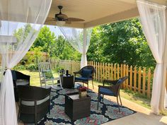 an outdoor covered patio with furniture and curtains