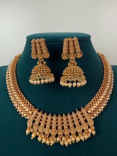 This exquisite piece of craftsmanship comes from our Traditional collection. Finish: 24 grams gold finish Necklace Fastening: Adjustable Dori  Perfect for Indian weddings. Earring jhumka Fastening: Push Back Contains: 1 necklace, 1 pair of earrings Luxury Gold Temple Necklace With Peacock Design, Luxury Temple Necklace With Peacock Design For Festivals, Gold Plated Round Temple Necklace For Festive Occasions, Festive Gold Plated Round Temple Necklace, Gold Plated Chandbali Necklaces For Celebration, Gold Plated Chandbali Necklace For Celebrations, Gold Chandbali Temple Jewelry Necklace, Heavy Gold Plated Temple Jewelry, Gold Plated Necklaces With Latkans For Festivals