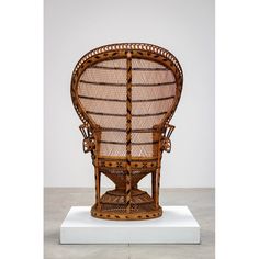 a wicker chair sitting on top of a white platform in front of a wall