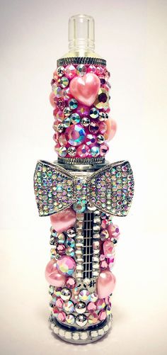 a bottle that has some beads on it and a bow around the neck with hearts