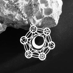 Unlock the divine energies of the universe with our captivating Archangel Metatron Cube Flower of Life Moon Necklace! 🌙✨ This exquisite piece of metaphysical jewelry combines the sacred symbols of the Metatron's Cube, the Flower of Life, and the phases of the moon, creating a powerful talisman for your spiritual journey. Crafted with utmost care and attention to detail, this necklace features a stunning pendant that showcases the intricate Metatron's Cube, a sacred geometric pattern that is bel Celestial Moon Jewelry For Meditation, Celestial Moon-shaped Jewelry For Meditation, Spiritual Nickel-free Moon Shaped Jewelry, Nickel-free Moon Shaped Spiritual Jewelry, Symbolic Metal Necklace With Moon Phase Detail, Symbolic Metal Moon-shaped Jewelry, Symbolic Moon Shaped Metal Jewelry, Symbolic Moon-shaped Metal Jewelry, Silver Jewelry With Sun And Moon Design For Meditation