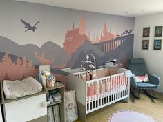 a baby's room decorated in pink, grey and white with a castle mural on the wall