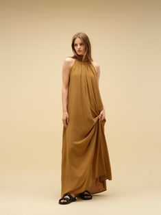 Imagine a dress that effortlessly blends comfort with a captivating wow factor. This statement piece features a flowy silhouette and eye-catching detailing. Crafted in soft, natural, breathable fabric, it can be worn in two ways, adding to its versatility. Available in a variety of colours and print. PRODUCT DETAILS Halter neck design Long maxi dress Versatile wear: can be worn in two ways, either loose or tight around the lower bust Loose fit or wraparound style Bump friendly Low back (elasticated at the back for seamless comfort) Long bow detail at the back for added elegance and style Designed in Australia Soft and light natural fabric Made with ecovero CONSIDERED NATURAL FABRIC Made with Lenzing EcoVero fabric, an eco-friendly sustainable material. EcoVero fabric has a very soft hand f Flowy Sleeveless Mini Dress, Chic Draped Maxi Dress For Fall, Chic A-line Flowy Maxi Dress, Spring Pre-draped Flowy Dress, Flowy Silk Pre-draped Maxi Dress, Chic A-line Viscose Maxi Dress, Flowy Draped Midi Dress For Spring, Flowy Draped Spring Dresses, Summer Silk Dresses With Fluid Fit