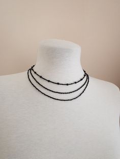 Set of 3 necklaces made of black beads. Elegant necklaces that you can present to yourself or your loved ones on special occasions. Each gothic choker necklace has a 1.5 inch adjustable chain. *First Necklace 14,17 inch / 36 cm *Second Necklace 15,94 inch / 40,5 cm *Third Necklace 18,11 inch / 46 cm   *Shipping costs for returns and exchanges belong to the buyer. *There may be some color and tone differences caused by different monitor settings. *It is not recommended to contact the jewelry with Minimalist Black Beaded Choker Necklace, Handmade Black Necklace For Layering, Black Handmade Necklace For Layering, Minimalist Black Beads For Gifts, Minimalist Black Beads For Gift, Minimalist Black Beads As Gift, Black Multi-strand Necklace Gift, Minimalist Black Beaded Necklaces As Gift, Minimalist Black Beaded Necklace For Gift