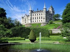 a large castle sitting on top of a lush green hillside