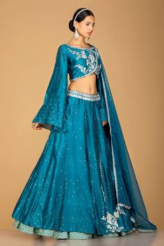 Wear this unique and exquisite layered blue embroidered designer chanderi silk lehenga on weddings! The lehenga is highlighted with silver embroidery and comes with a matching dupatta. Shop online from Pure Elegance.Ready Blouse Size: 38"Ready Lehenga Length: 43" Blue Kundan Set For Reception, Blue Anarkali Silk Lehenga, Blue Silk Anarkali Lehenga, Blue Chanderi Gown With Zari Work, Blue Tissue Silk Choli With Dupatta, Blue Chanderi Wedding Choli, Blue Chanderi Lehenga For Wedding, Blue Tissue Silk Lehenga With Zari Work, Blue Tissue Silk Sharara For Reception