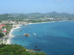 an aerial view of a beach with boats in the water