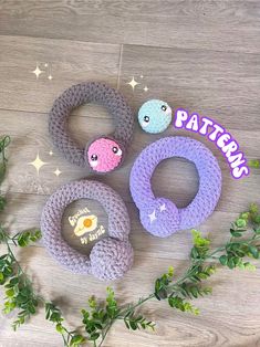 three crocheted rings sitting on top of a wooden floor next to greenery