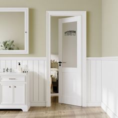 there is a bathroom with white walls and wood flooring, along with two mirrors on the wall