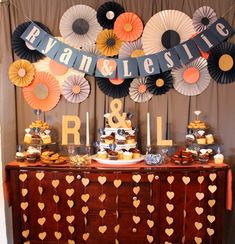 a buffet table with cupcakes and desserts on it, decorated with paper fans