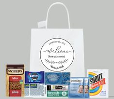 a white shopping bag with some snacks on the front and side, along with other items