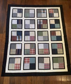 a black and white quilt is on the floor in front of a wooden floor with wood floors